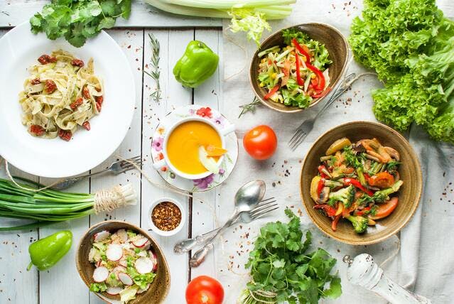 Kolorowe, zdrowe potrawy pełne warzyw na białym stole